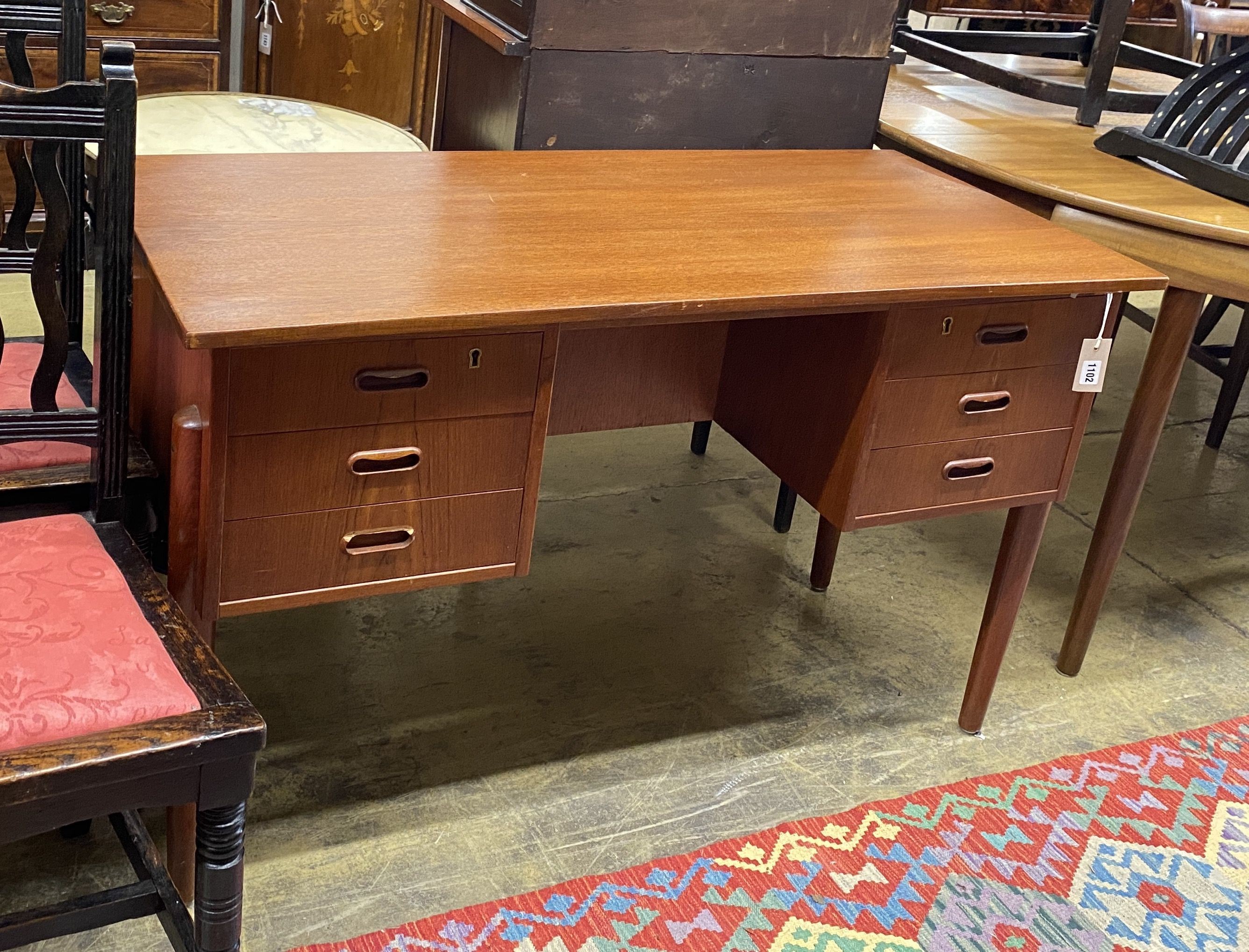 A mid century Danish teak kneehole dressing table of rectangular concave form, width 116cm, depth 55cm, height 72cm